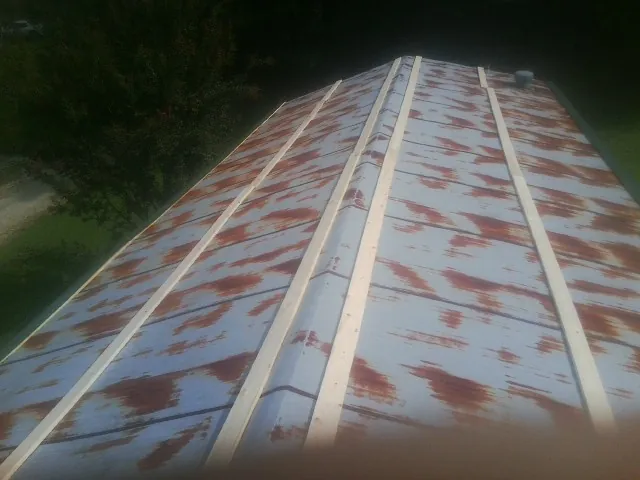 Rusted metal roof panels with new wood purlins before replacement — Storm Damage Roof Repair in Cody by Roofing Brothers