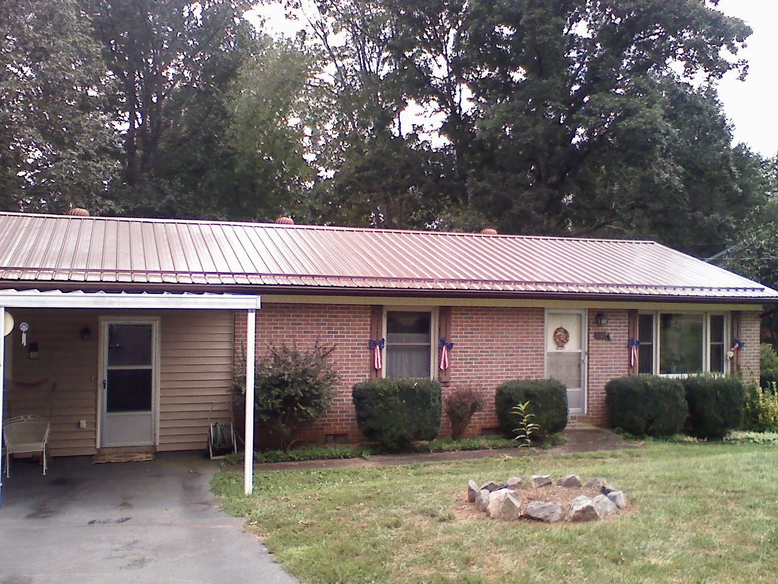 Bronze metal roof and carport on a brick ranch home — Roof Repair work by our crew in Cody